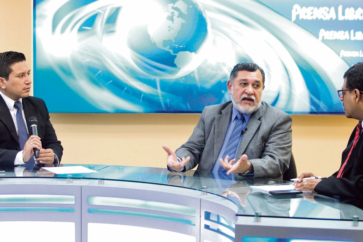 Leonel Escobar, del TSE —al centro—, conversa con los periodistas Álex Rojas y Manuel Hernández sobre los requisitos para que los ciudadanos acudan a las urnas.