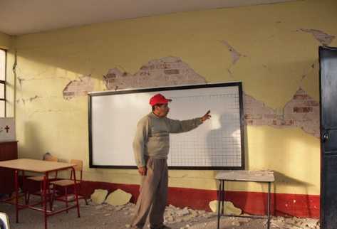 docente señala los daños en paredes de la Escuela Naciones Unidas, en San Marcos.