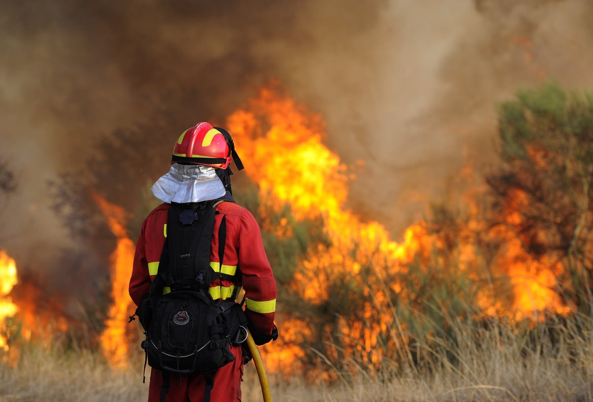 <em>Un bombero trabaja para sofocar las llamas. (Foto Prensa Libre: AFP).</em>