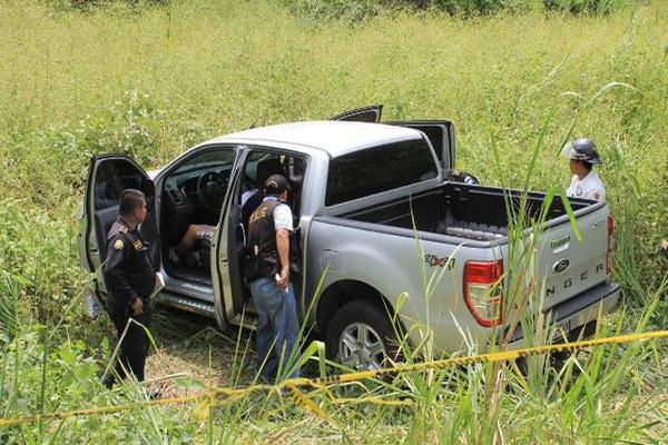 La Policía inspecciona el lugar donde quedó el picop en cuyo interior fue localizado un hombre muerto. (Foto Prensa Libre: Enrique Paredes)