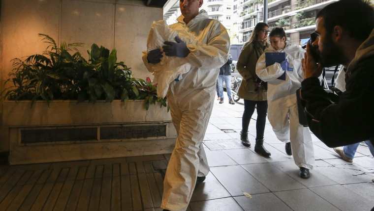Forenses llegan al edificio de apartamentos donde fue hallado el cadáver del ejecutivo Horacio Quiroga. (Foto Prensa Libre: EFE).