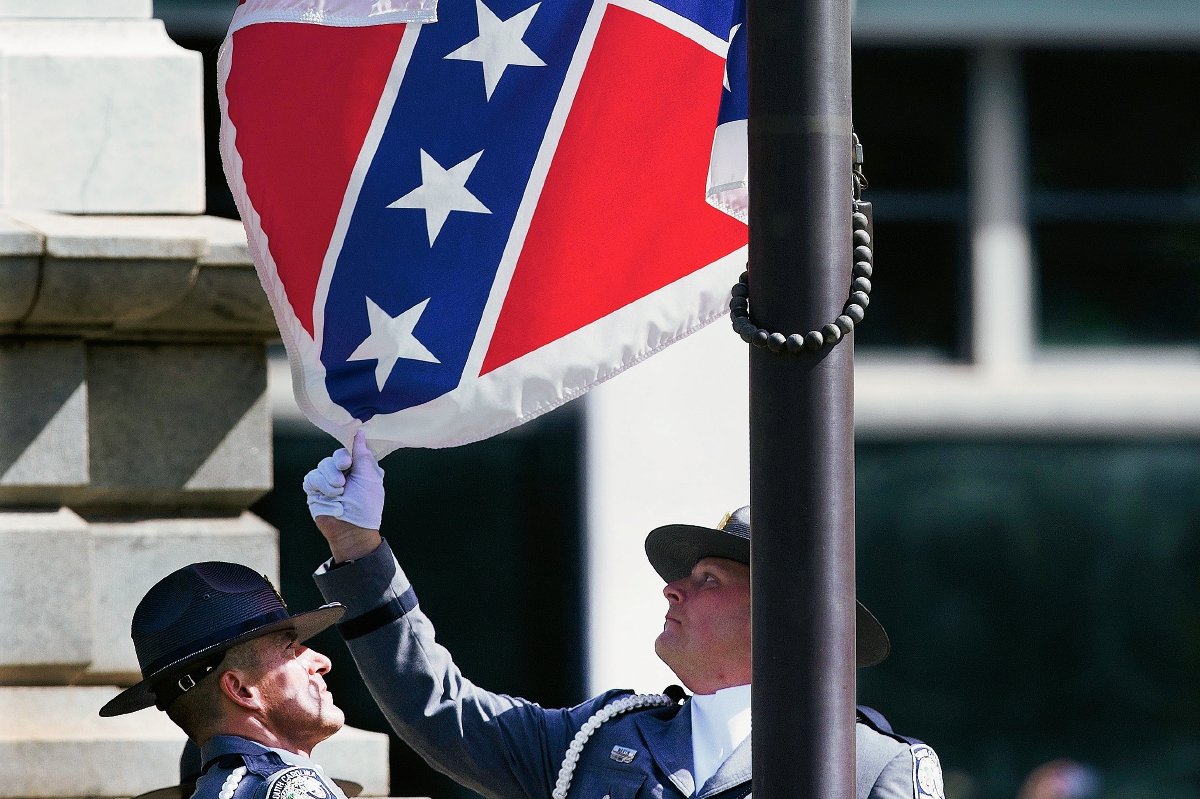 Momento en que la bandera Confederada es retirada. (Foto Prensa Libre: AP).