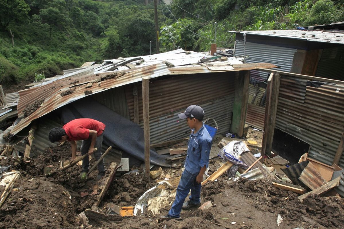 Marlon Iván López, de 19 años, remueve los escombros de lo que fue su casa en busca de documentos personales. (Foto Prensa Libre: Carlos Hernández)