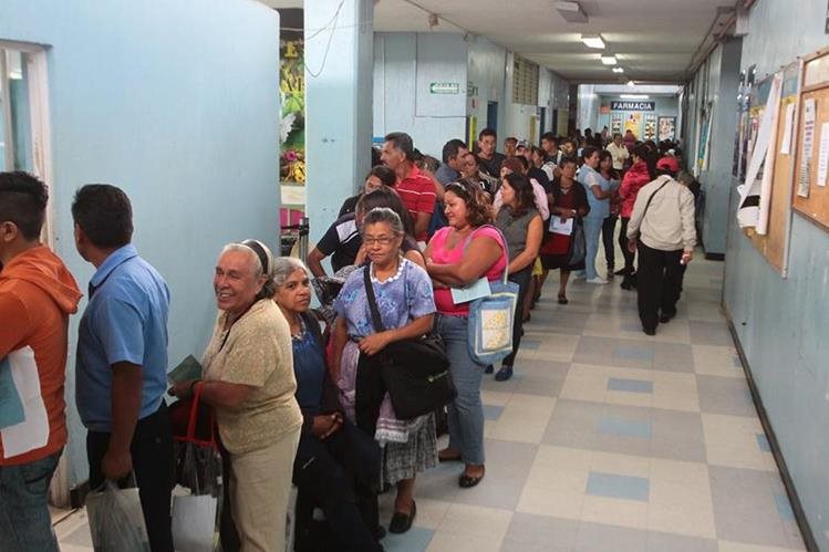 Personas hacen fila de pie para obtener atención médica en el sistema público. (Foto Prensa Libre: Hemeroteca PL)