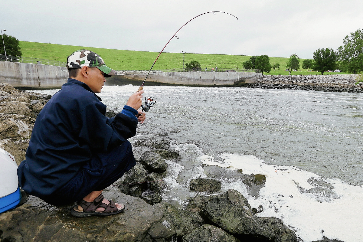 Maung Htway, de Des Moines, Iowa, se dedica  la pesca en la represa en Saylorville. (Foto Prensa Libre:AP).