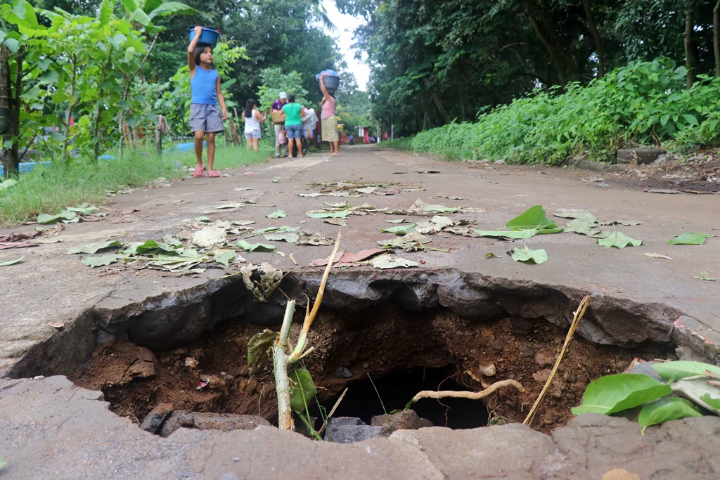 Dos agujeros que se formaron en la calle principal del cantón Recuerdo Ocosito, Retalhuleu, podrían dejar incomunicadas a unas 150 familias del sector. (Foto Prensa Libre: R. Miranda)