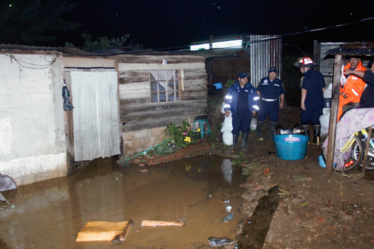 Bomberos Municipales  Departamentales, trabajaron durante tres horas para extraer el agua de las viviendas inundadas, debido a la fuerte lluvia. (Foto Prensa Libre: Renato Melgar)