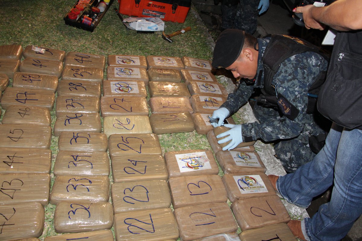 La policía revisa los 76 paquetes de cocaína incautados en Mixco. (Foto Prensa Libre: PNC)