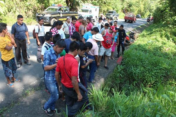 Vecinos observan el lugar donde fue localizado el cadáver de un hombre en El Quetzal, San Marcos. (Foto Prensa Libre: Alexander Coyoy).