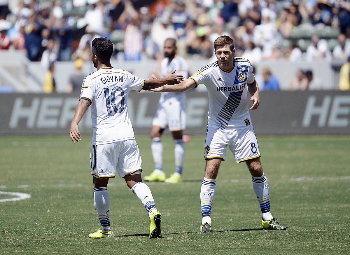 Steven Gerrard y el mexicano Gio Dos Santos durante el juego de ayer de Los Ángeles. (Foto Prensa Libre: AFP)