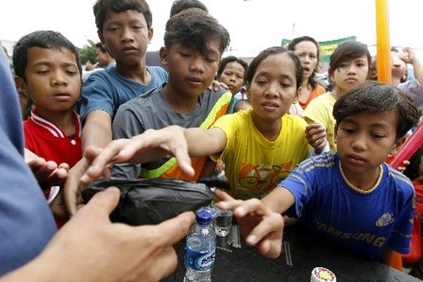 Un grupo de niños recibe alimentos en un campo de refugiados de Yakarta. (FotoPrensa Libre:EFE)
