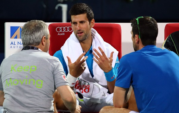 Novak Djokovic recibe atención médica durante el partido contra Feliciano López. (Foto Prensa Libre: AFP).