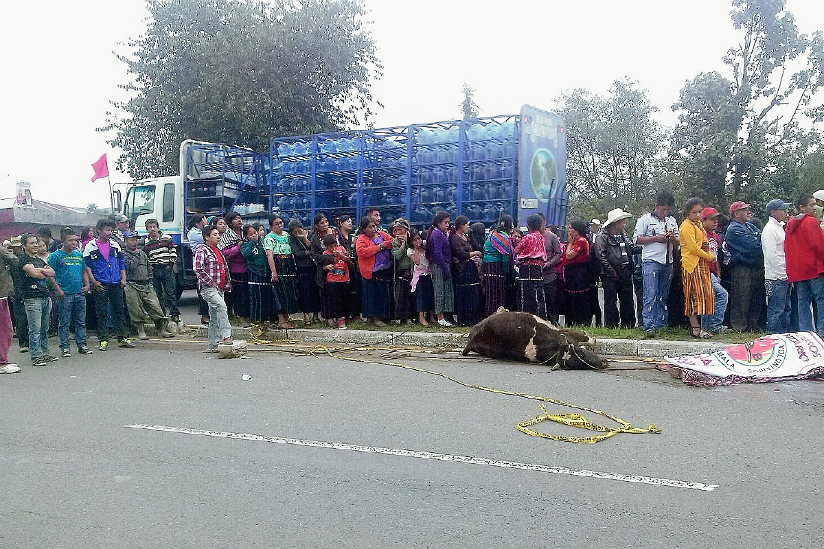 Pobladores de Nahualá, Sololá, observan las víctimas mortales que yacen en la cinta asfáltica. (Foto Prensa Libre: Ángel Julajuj)