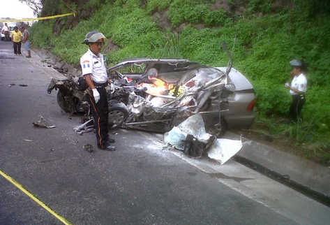 Bomberos observan el vehículo en el que se desplazaban las dos víctimas mortales. (Foto Prensa Libre: Enrique Paredes)