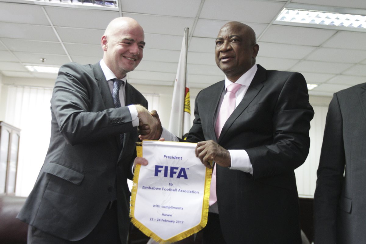 Gianni Infantino saluda a Philip Chiyangwa, presidente de la Asociación de Futbol de Zimbabwe. (Foto Prensa Libre: AP)