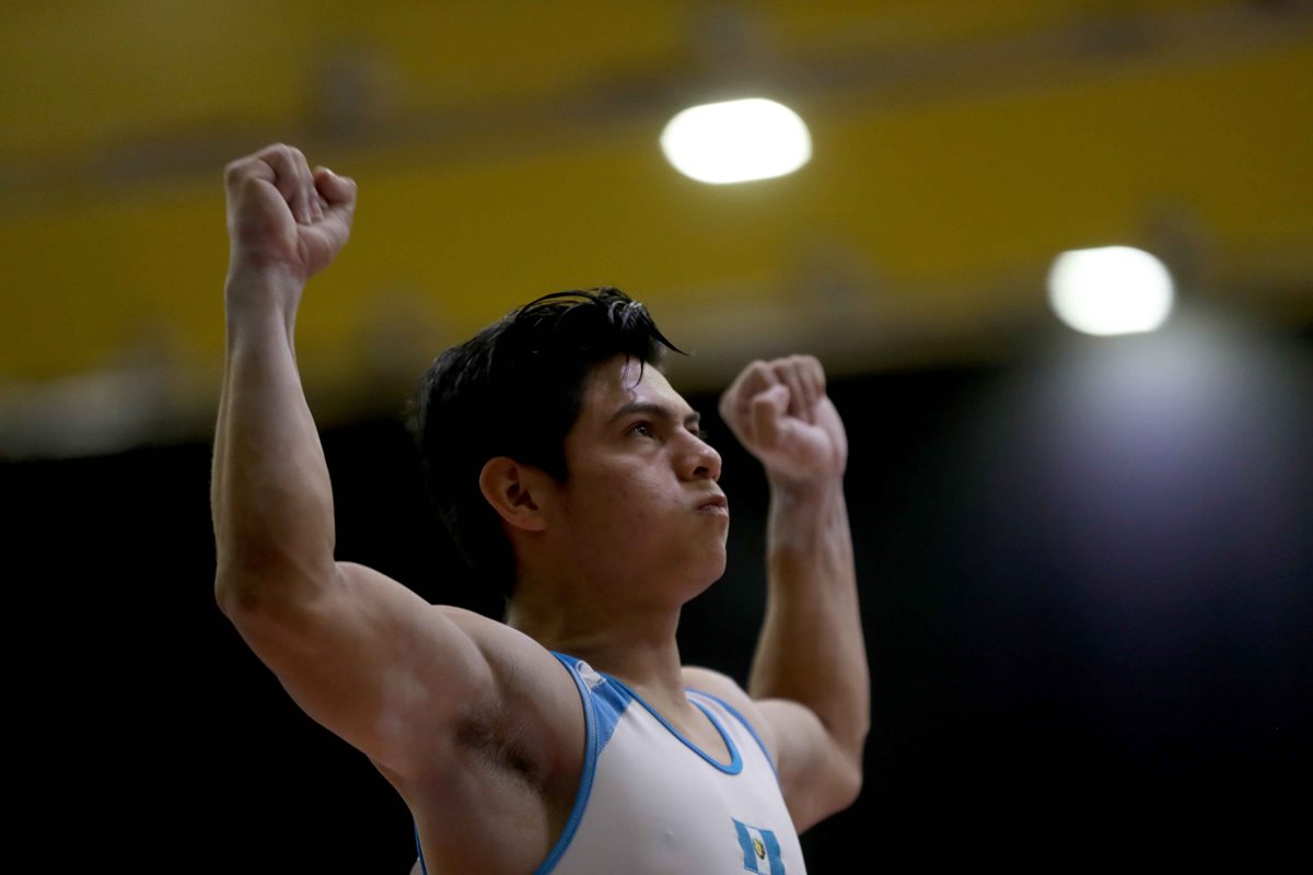 Jorge Vega alza los brazos al finalizar su rutina de piso. (Foto Prensa Libre: Carlos Vicente)