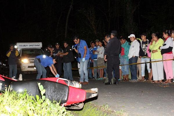 Curiosos observan el cadáver de Fernández Juárez, quien murió en un accidente de tránsito, en Retalhuleu. (Foto Prensa Libre: Rolando Miranda) 