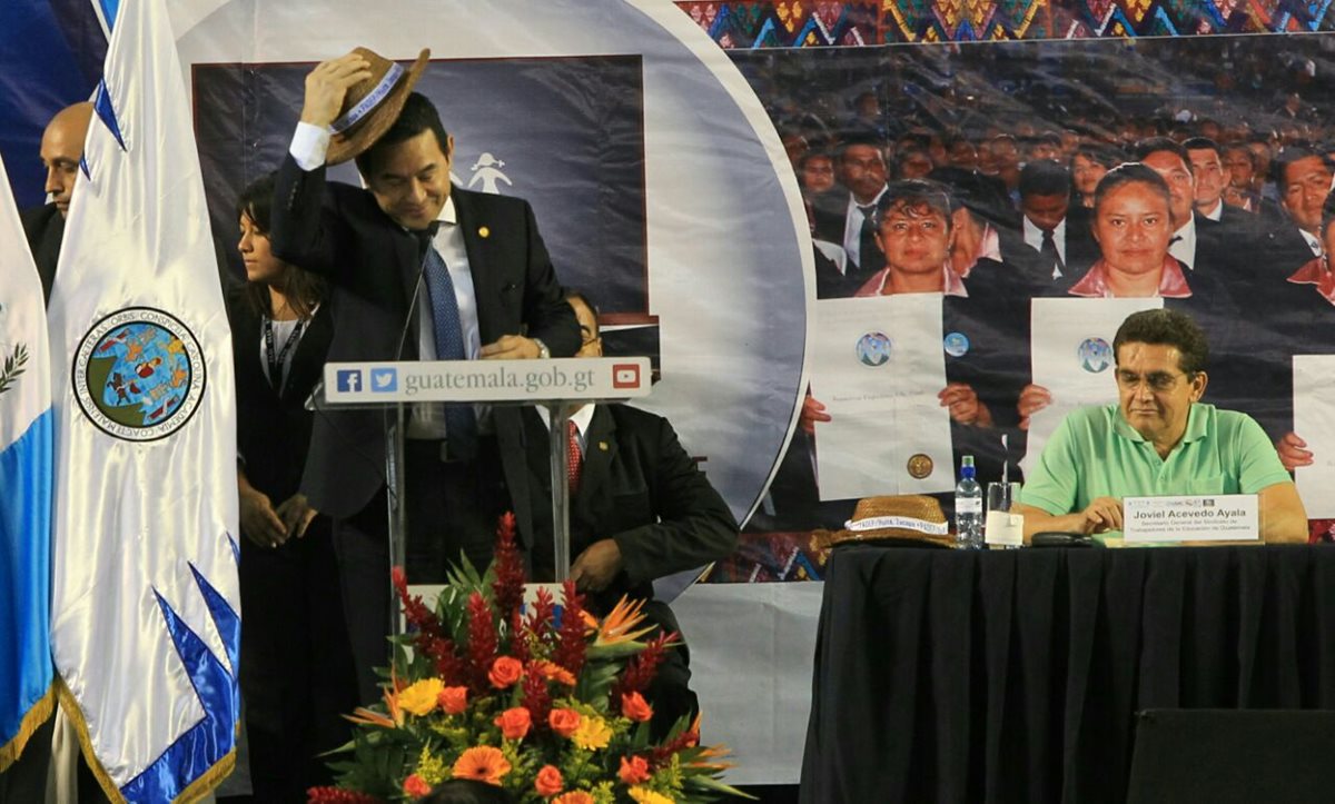El presidente Jimmy Morales, se coloca un sombrero durante una actividad del magisterio, donde lo acompaña el dirigente del Steg, Joviel Acevedo. (Foto Prensa Libre: Esbin García)