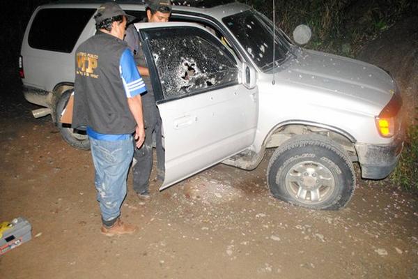 Policías revisan el automóvil agrícola en que viajaban tres catequistas abatidos a tiros en una aldea de Los Amates, Izabal. (FOTO PRENSA LIBRE: Edwin Perdomo)<br _mce_bogus="1"/>