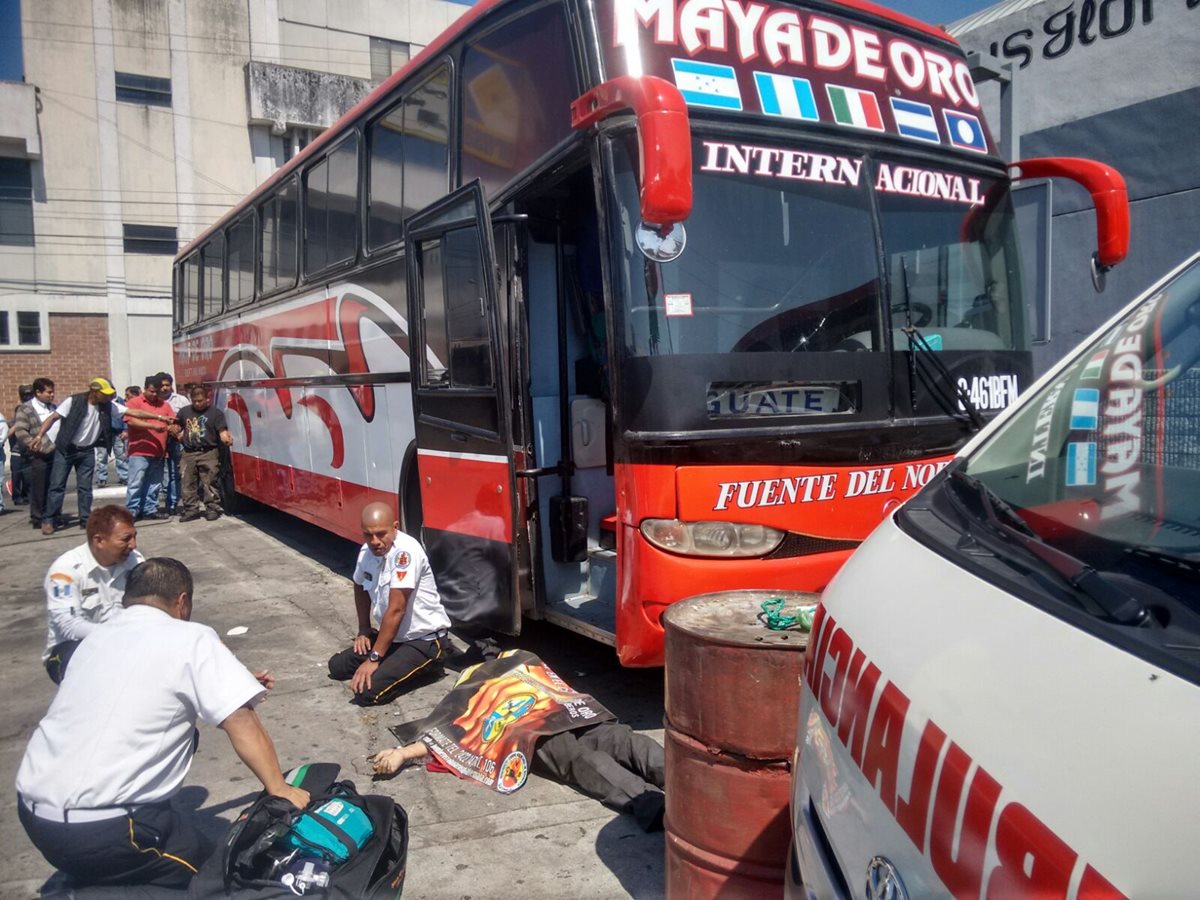 El cuerpo de un mecánico quedó tendido a una terminal de buses. (Foto Prensa Libre: Bomberos Voluntarios)