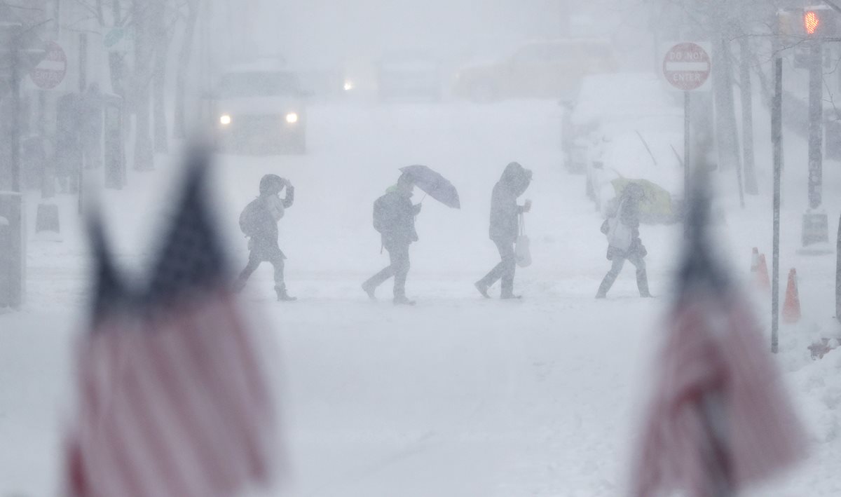 Personas en Nueva Jersey cruzan una calle completamente cubierta por la nieve. (Foto Prensa Libre: AP)