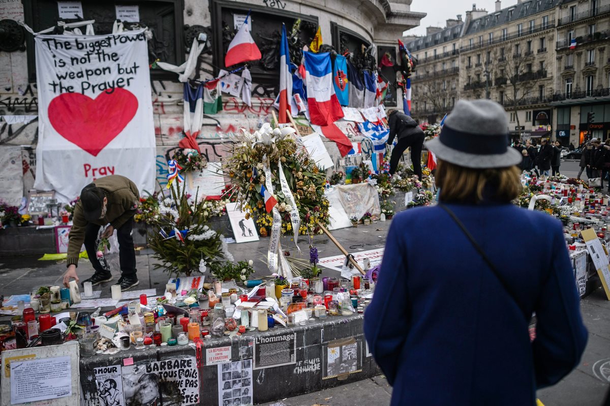 Velas y fotografías son llevadas por los franceses para recordar a las víctimas de la masacre. (Foto Prensa Libre: EFE).