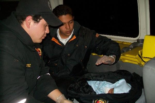 Socorrista  y policía observan a la bebé,  tras   haber sido rescatada.