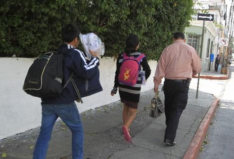 Julio López, de Malacatán, San Marcos, lleva a sus hijos, quienes el lunes fueron deportados de México. Los menores pasaron la noche en un albergue.