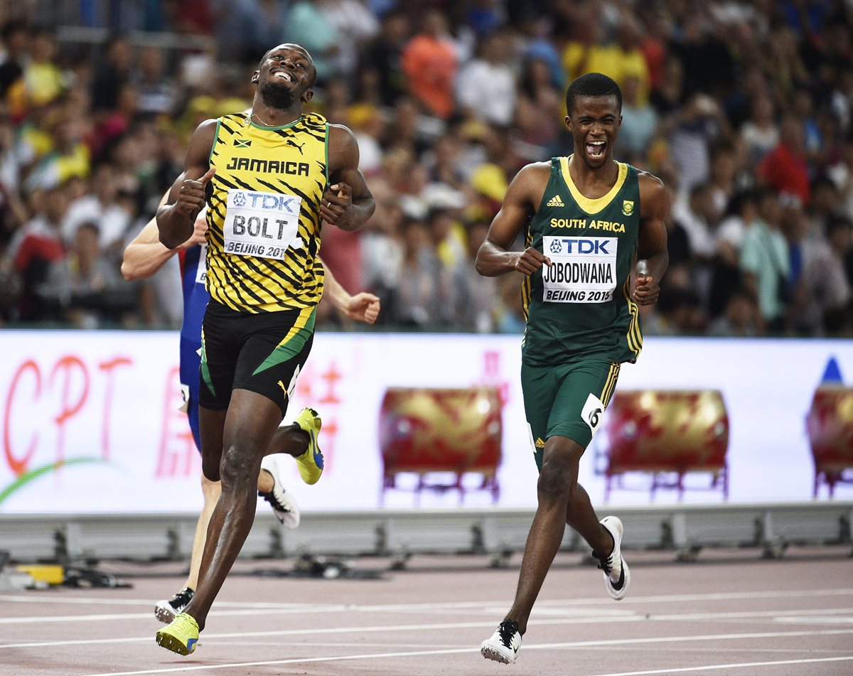 Usain Bolt y Anaso Jobodwana sonríen tras cruzar la línea de meta en primera y segunda posición, respectivamente, en la semifinal de los 200 metros. (Foto Prensa Libre: EFE)