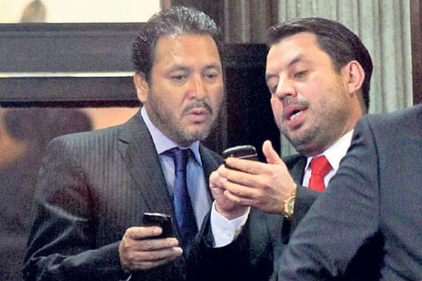 Gudy Rivera, del PP y expresidente del Congreso, y Salvador Baldizón, de Líder, revisan información.