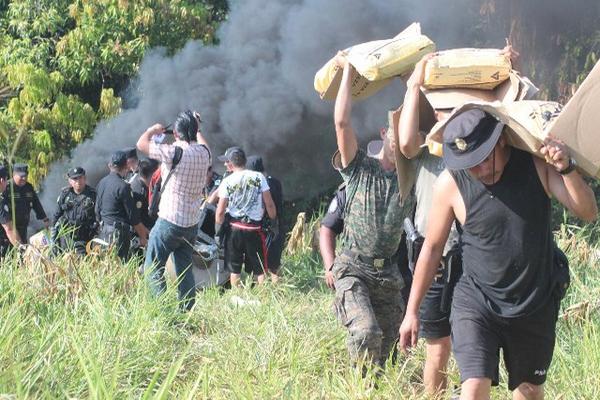 Varios soldados cargan costales de soda caustica, la cual estaba ubicada en el laboratorio para fabricar drogas sintéticas que fue localizado en Catarina, San Marcos. (Foto Prensa Libre)