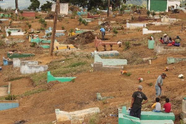 Pobladores de Santiago Sacatepéquez limpian las tumbas antes de la celebración del Día de los Difuntos.