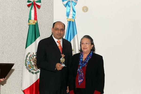El editor de Tododeportes, Hugo Castillo Aragón, recibe el reconocimiento de la señora María Mercedes Girón de Blank, presidenta del Consejo de Administración de Prensa Libre. (Foto Prensa Libre: Carlos Morales)