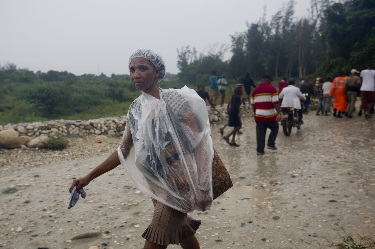 Una mujer camina en un poblado de Haití, fuertemente golpeado por el huracán "Matthew". (Foto Prensa Libre: AP).