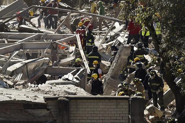 Paramédicos y voluntarios buscan sobrevivientes bajo los escombros del hospital materno-infantil del Distrito Federal. (Foto Prensa Libre: AFP).