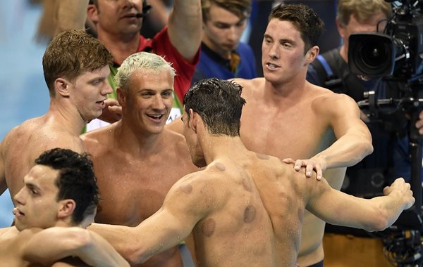 Michael Phelps (de espaldas) es felicitado por sus compañeros, después de cerrar de gran manera la prueba de natación de 4X200 metros (Foto Prensa Libre: AP)