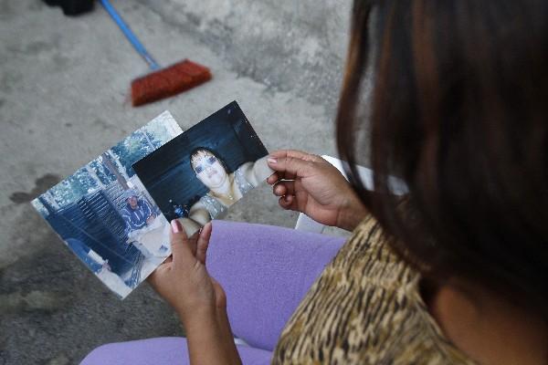 una familiar observa las fotos  de los padres de los hermanos Rosales Hernández.