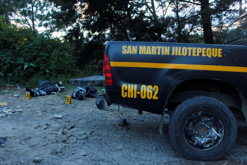 Agentes de la PNC trasladan cadáveres de dos hombres, en San Martín Jilotepeque, Chimaltenango. (Foto Prensa Libre: Víctor Chamalé)