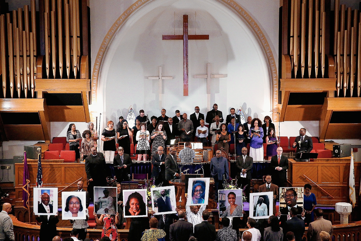 Fotografías de las nueve víctimas asesinadas en la iglesia Episcopal Metodista Emanuel, que familiares y amigos portaron durante una vigilia el jueves último. (Foto Prensa Libre: AFP).