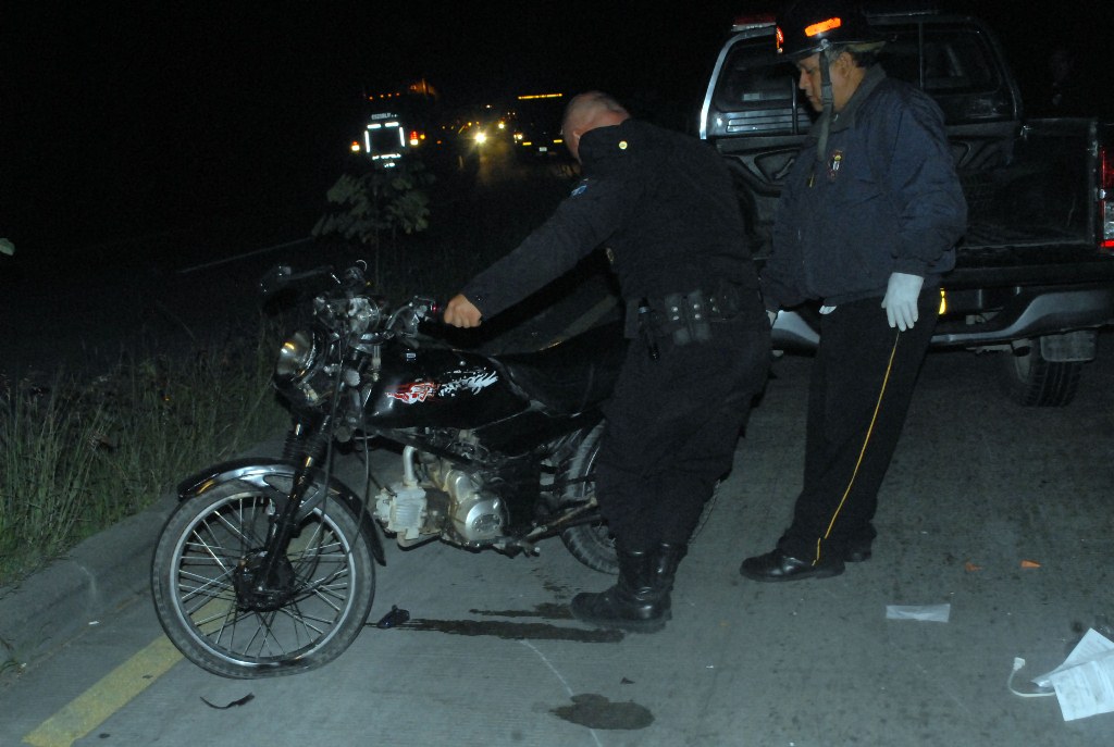 Agentes de la PNC inspeccionan motocicleta en la que viajaba Luis Antonio López. (Foto Prensa Libre: Hugo Oliva)