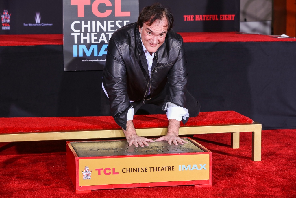 Quentin Tarantino coloca sus manos en el cemento durante una ceremonia en el teatro chino de Hollywood. (Foto Prensa Libre: AP)