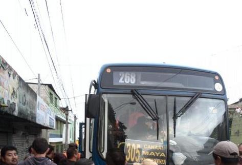 Algunos curiosos observan el lugar del ataque ocurrido en contra de pasajeros de Transurbano con ruta a colonia Maya, zona 18. Foto Prensa Libre: Claudia Galán).