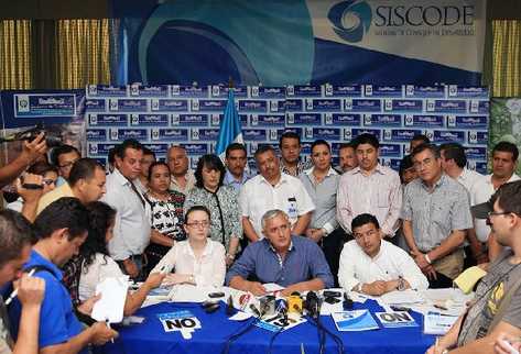 El mandatario  escucha preguntas de periodistas después de la sesión del Conadur. Lo acompañan Ekaterina Parrilla, de Segeplán, y Germán Velásquez, de la Secretaría Ejecutiva.