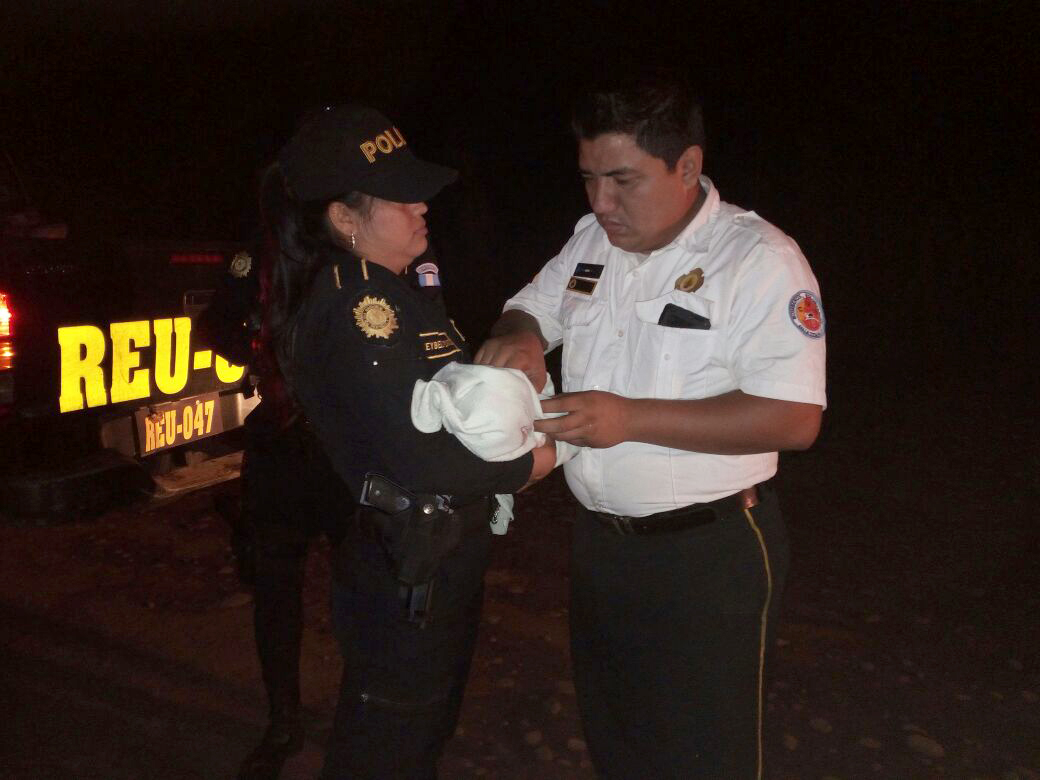 Una agente de la Policía Nacional Civil (PNC) y un bombero voluntario rescatan a una recién nacida que fue abandonada en Caballo Blanco, Retalhuleu. (Foto Prensa Libre: Rolando Miranda)