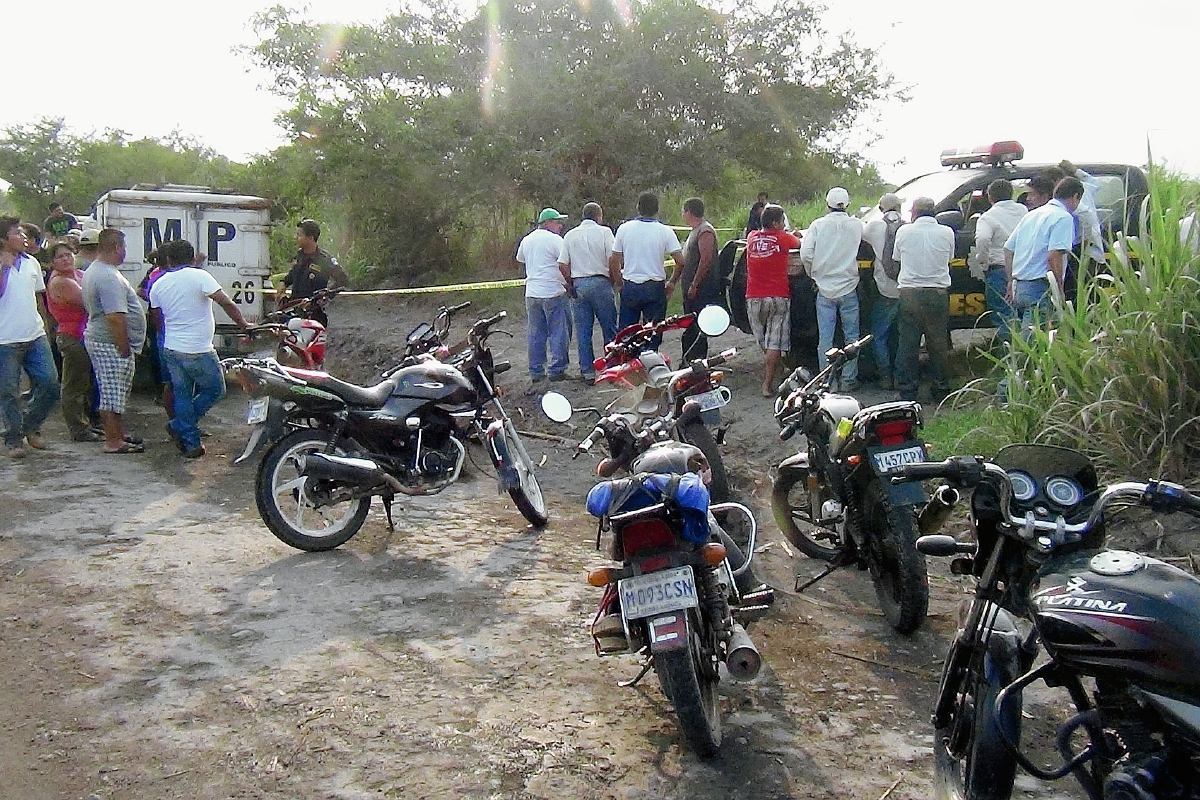 Fiscales del  Ministerio Público acordonan área donde fue localizado el cadaver de un hombre con heridas de machete, en Santa Lucía Cotzumalguapa, Escuintla. (Foto Prensa Libre: Carlos Enrique Paredes)