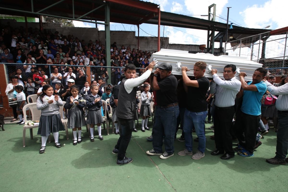 Padres y maestros cargan el ataúd de la seño Gaby durante el homenaje en su escuela. (Foto Prensa Libre: Paulo Raquec)