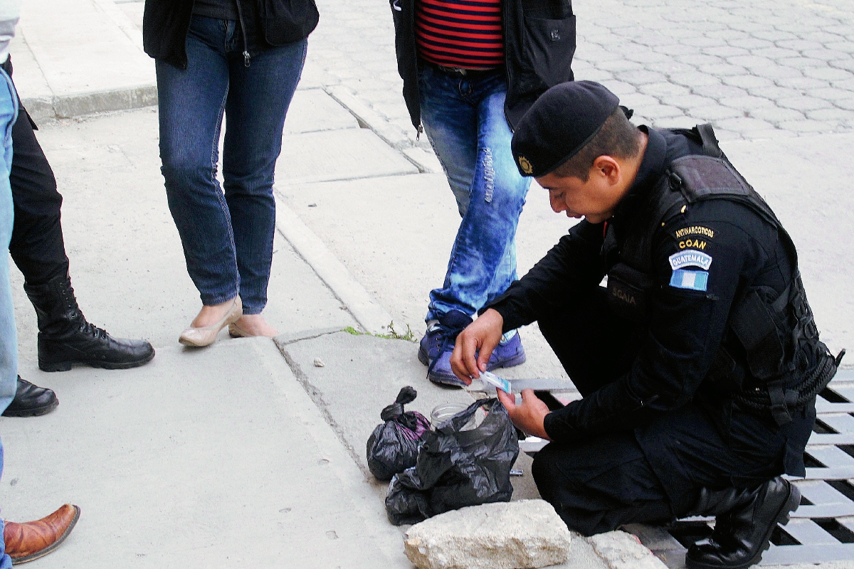 Un agente antinarcótico efectúa pruebas a la sustancia que llevaba una menor, y comprueba que es cocaína. (Foto Prensa Libre: Hugo Oliva)