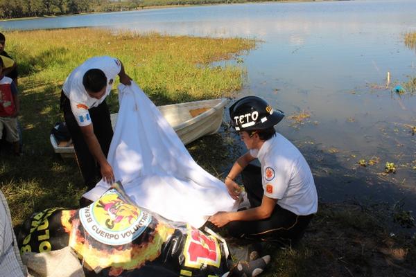 Los cadáveres fueron sacados de la laguna por Bomberos Voluntarios y vecinos. (Foto Prensa Libre: Oswaldo Cardona)<br _mce_bogus="1"/>