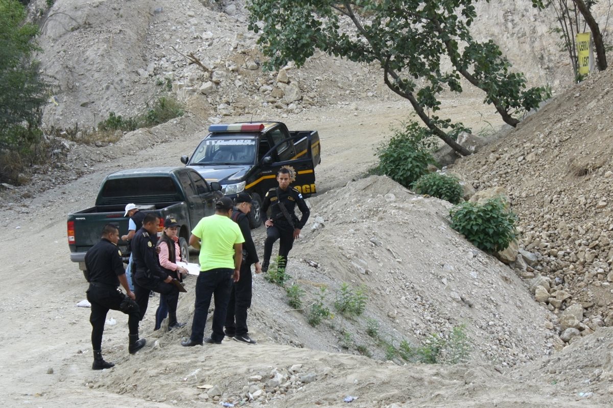 Agentes policiales observan el cadáver del hombre que fue localizado en una hondonada, en el kilómetro 67.7 de la ruta al Atlántico. (Foto Prensa Libre: Héctor Contreras)