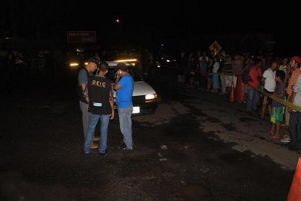 Curiosos observan el lugar donde murió baleado el taxista Mario Humberto Jiménez, en Escuintla. (Foto Prensa Libre: Enrique Paredes) 